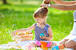 Foto: Little cute girl playing at a picnic Little cute girl playing at a picnic