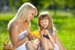 Beautiful smiling young mother and little daughter at a picnic