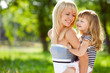 Foto: Beautiful young mother holds her little happy daughter on a back Beautiful young mother holds her little happy daughter on a back