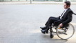Business man in wheelchair talking into smartphone