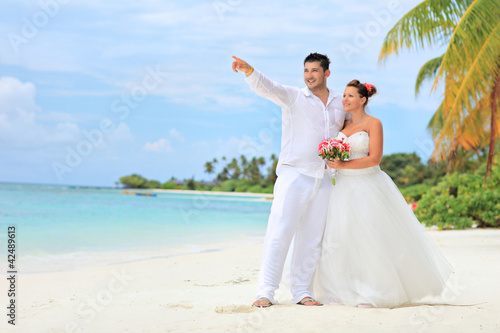 Foto: Bride and groom embracing on beach, Kuredu island, Maldives Bride and groom embracing on beach, Kuredu island, Maldives