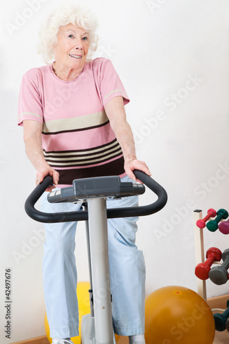 Foto: Happy Senior Woman Exercising On Bike Happy Senior Woman Exercising On Bike