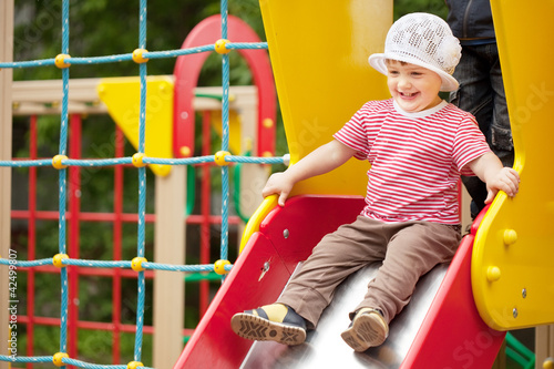 Photo: Happy two-year child on slide Happy two-year child on slide