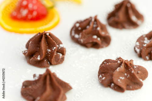 Foto: Small Tartufoes chocolate in an elegant dish. Small Tartufoes chocolate in an elegant dish.