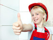 Foto: Cute girl with helmet showing thumb up for renovating the bath Cute girl with helmet showing thumb up for renovating the bath