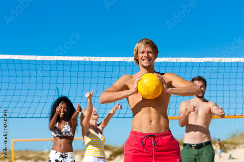 Foto: Friends playing beach volleyball Friends playing beach volleyball