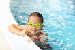 Schoolgirl with goggles in swimming pool