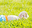 Little dreaming baby laying on the grass