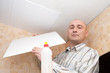 Man glues ceiling tile