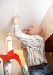 Man glues ceiling tile
