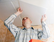 Man glues ceiling tile