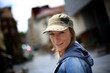 Foto: Cheerful woman wearing blue jeans jacket and hat in town Cheerful woman wearing blue jeans jacket and hat in town
