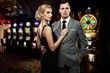 Foto: Retro couple against slot machines Retro couple against slot machines