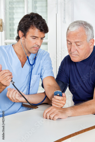 Photo: Male Nurse Checking Blood Pressure Of a Senior Man Male Nurse Checking Blood Pressure Of a Senior Man