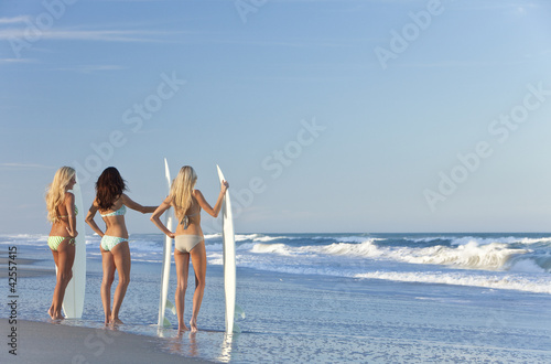 Photo: Three Beautiful Women Surfers In Bikinis Surfboards At the Beach Three Beautiful Women Surfers In Bikinis Surfboards At the Beach