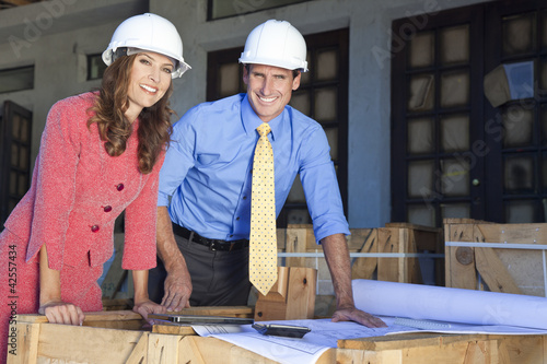 Foto: Man & Woman In Hard Hats on Construction Site Man & Woman In Hard Hats on Construction Site