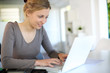 Beautiful young woman studying at home on laptop