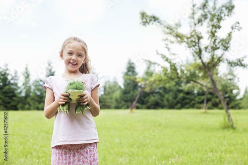 Foto: Portrait of a happy girl holding stuffed toy in park Portrait of a happy girl holding stuffed toy in park