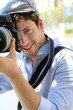 Portrait of young photographer holding camera