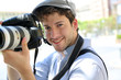 Portrait of young photographer holding camera