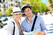 Trendy young couple in town with touristic map