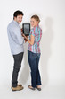 Young couple on white background holding digital tablet