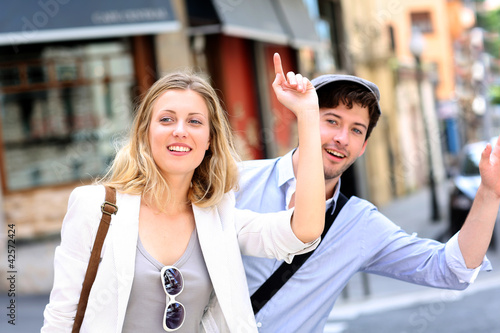 Photo: Young couple hailing for a taxi cab Young couple hailing for a taxi cab