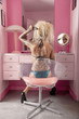 Foto: Back view of woman sitting on chair brushing hair in dressing room Back view of woman sitting on chair brushing hair in dressing room