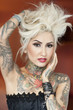 Portrait of beautiful tattooed woman with hand in hair