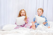 Two merry children playing on the bed