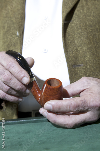 Photo: Close-up view of owner holding tobacco pipe Close-up view of owner holding tobacco pipe