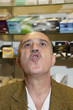 Foto: Mature man in tobacco store blowing smoke Mature man in tobacco store blowing smoke