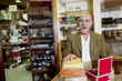 Portrait of a mature man smoking cigar with display in background