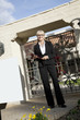 Photo: Portrait of a senior woman standing with clipboard in front of entrance gate Portrait of a senior woman standing with clipboard in front of entrance gate