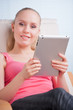 Foto: Young beautiful student using a tablet computer while relaxing Young beautiful student using a tablet computer while relaxing