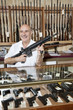 Foto: Happy mature man with rifle in gun store Happy mature man with rifle in gun store