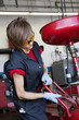Photo : Young female mechanic working on welding equipment Young female mechanic working on welding equipment