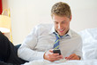 Mann mit Handy auf Bett