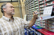 Happy mature man looking at staple pack in store