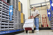 Photo: Mature man pushing handtruck in hardware store Mature man pushing handtruck in hardware store