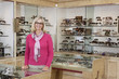 Foto: Portrait of a happy senior female optician standing in store Portrait of a happy senior female optician standing in store