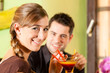 Young couple drinking cocktails in bar or restaurant