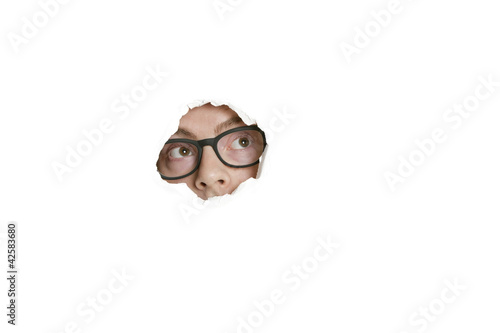 Photo: Mid adult Caucasian man looking away from ripped paper hole Mid adult Caucasian man looking away from ripped paper hole