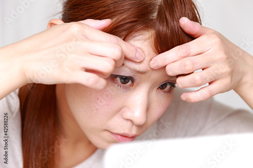 Photo: woman worries about a pimple woman worries about a pimple