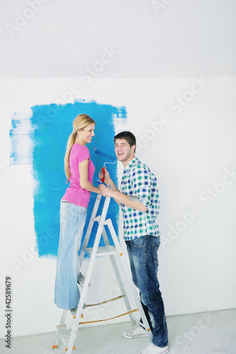 Foto: happy couple paint wall at new home happy couple paint wall at new home