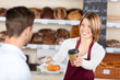 Photo: verkäuferin mit croissant und kaffeebecher verkäuferin mit croissant und kaffeebecher