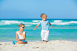 Young girl and boy playing happily at pretty beach