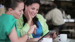 Video: Two friends with tablet computer sitting in cafe, steadicam shot Two friends with tablet computer sitting in cafe, steadicam shot
