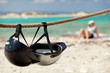 Helmets on the beach. Young woman relaxing on the background.