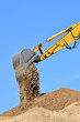 new yellow excavator working on sand dunes. Scoop close-up